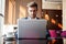 Young businessman working on laptop, sitting in hotel lobby waiting for someone.