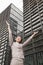 Young businesswoman with arms outstretched among skyscrapers, Beijing