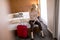 Young businesswoman arrives in a hotel room with red suitcase an