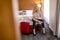 Young businesswoman arrives in a hotel room with red suitcase an