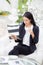 Young businesswoman asian sitting at table looking tablet and holding coffee cup.