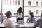 Young businesswoman and colleagues at meeting, looking away