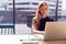 Young Businesswoman At Desk In Modern Office Work Space Using Laptop With Focus On Foreground