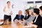 Young businesswoman doing presentation to colleagues in office