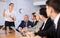 Young businesswoman doing presentation to colleagues in office