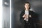 Young businesswoman in the elevator checking time on her watch. Female office worker checking time and waiting for the elevator to