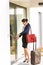 Young businesswoman locking door traveling luggage leaving