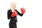 A young businesswoman with red boxing gloves ready to fight