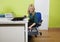 Young businesswoman searching something in drawer with laptop and file folder on desk