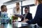 Young businesswoman showing project to businessman during meeting in office