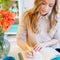 Young businesswoman sitting at desk and working. Beautiful woman fills planner