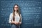 Young businesswoman standing on the background of blackboard with mathematical formulas