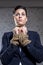 Young businesswoman standing with tied hands against wall at office