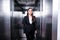 young businesswoman, suffering from claustrophobia, standing in elevator and looking at camera.