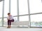 Young businesswoman using smartphone while sitting on radiator at new empty office