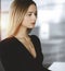 Young businesswoman while working in a sunny cabinet of her firm. Business headshot or portrait of a secretary, sitting