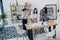 Young businesswomen working with blueprint and drinking coffee in modern office