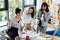 Young businesswomen working with blueprint and drinking coffee in office