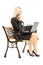 Young busy businesswoman sitting on a bench and working on a lap