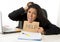 Young busy desperate Latin businesswoman holding help sign sitting at office desk in stress worried