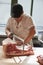 Young butcher sawing meat at a butcher\'s shop, vertical