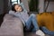 Young calm girl relaxing leaning back with her hands behind her head on a comfortable sofa, dreaming, tired girl resting on the