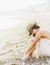 Young calm woman relax sitting on a sand sea beach, romantic foggy morning.