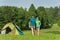 Young camping couple hugging in summer countryside