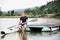 Young canoeist sitting on wooden dock. Concept of canoeing as dynamic and adventurous sport.