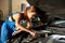 Young car mechanic woman repairing car at service station