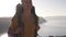 Young, carefree girl with backpack is walking along the top of mountain lake against the backdrop of mountains. Summer