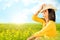 Young carefree woman sitting in green field.