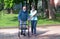 Young caregiver accompanies an elderly gentleman helping him to walk in the park