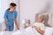 Young caregiver assisting senior woman in bedroom. Home health care service