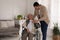 Young caregiver assisting senior woman in wheelchair indoors. Home care service