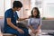 A young caregiver is consulting with a 60-year-old Asian elderly woman, providing encouragement and taking a medical