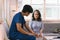 A young caregiver is consulting with a 60-year-old Asian elderly woman, providing encouragement and taking a medical