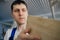 A young carpenter chooses a wooden board. Inspection and quality control of wood. Worker in the carpentry shop