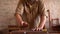 Young carpenter sanding wood in workshop