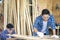 Young Carpentry workshop`s boss woodworking. Wood processing apprenticeship at carpentry shop