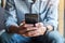 Young casual Businessman holding and using smartphone for sms messages, hipster man typing touchscreen cell phone in the cafe.