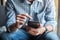 Young casual Businessman holding and using smartphone for sms messages, hipster man typing touchscreen cell phone in the cafe.