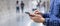 Young casual Businessman holding and using smartphone for sms messages, tourist man typing touchscreen cell phone in subway.