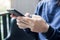 Young casual Businesswoman holding and using smartphone for sms messages, woman typing touchscreen cell phone in the cafe.