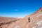 Young casual man with backpack on the path at moon like landscape of Valle de la Luna Moon valley, Chile