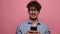 Young casual man with glasses on pink background