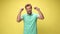 young casual man in green polo shirt on yellow background