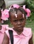 Young Catholic kindergarten school girl poses for camera in rural village.