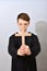 A young Catholic priest holds a cross in front of him. The concept of driving out the devil and evil spirits