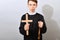 A young Catholic priest holds a cross and a rosary in his hand
